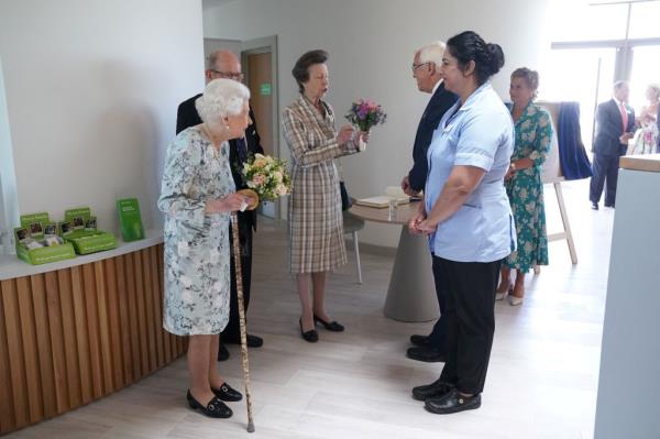 Britain's Queen Elizabeth II and Britain's Anne (C), Princess Royal, are greeted by staff during a visit to officially open the new building of Thames Hospice in Maidenhead, Berkshire, on July 15, 2022.